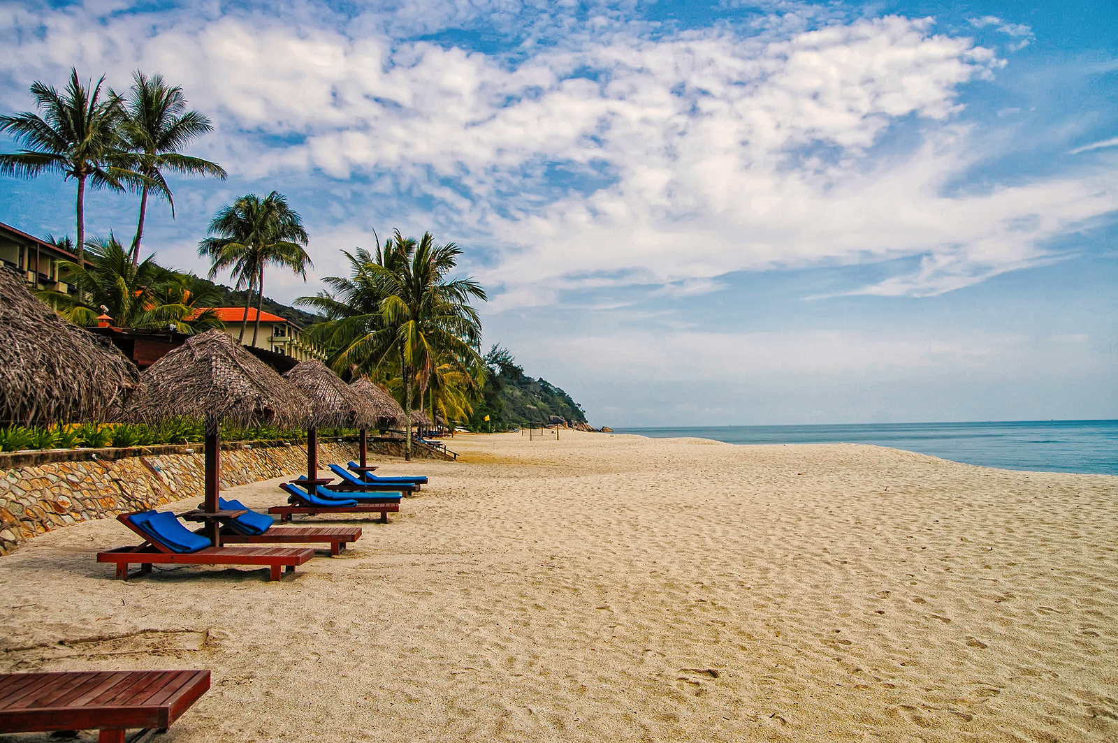 Sand tropic palms and sunbeds. Best Kuantan beach resorts.
